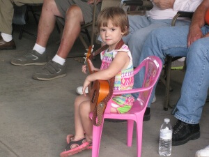 Little girl at the Bluegrass festivals with a guitar